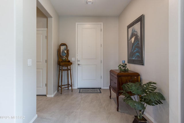 entryway featuring light tile patterned flooring, baseboards, and visible vents