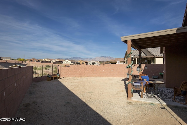 view of yard with a mountain view, a residential view, and a fenced backyard