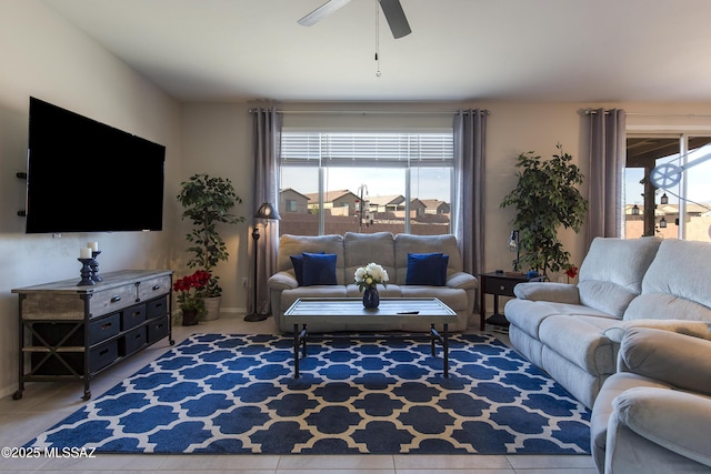tiled living area with a ceiling fan and baseboards