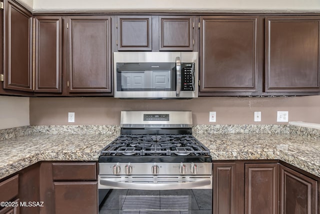 kitchen with appliances with stainless steel finishes and dark brown cabinets