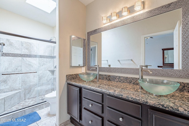 bathroom featuring a sink, a shower stall, and toilet
