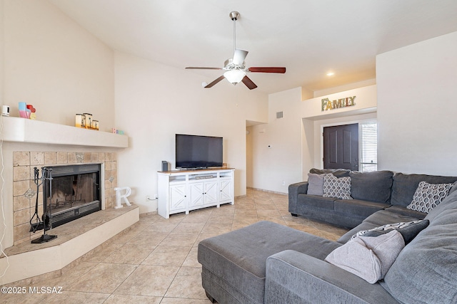 living area with light tile patterned floors, a fireplace, a ceiling fan, and visible vents