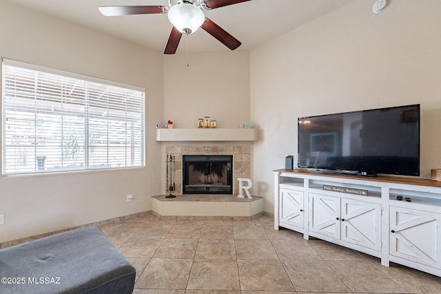 living room featuring ceiling fan, light tile patterned floors, and a tile fireplace