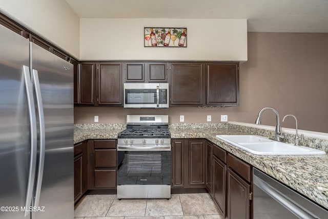 kitchen with light tile patterned floors, dark brown cabinetry, appliances with stainless steel finishes, and a sink