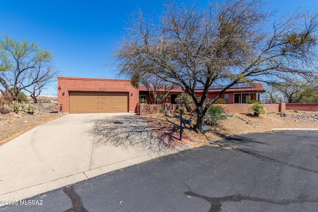 ranch-style house featuring a garage, fence, covered porch, brick siding, and concrete driveway
