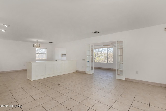 empty room with light tile patterned floors, baseboards, and french doors