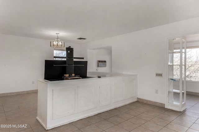 kitchen featuring light tile patterned flooring, a notable chandelier, baseboards, heating unit, and visible vents