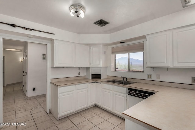kitchen with white cabinets, white dishwasher, a sink, light countertops, and visible vents