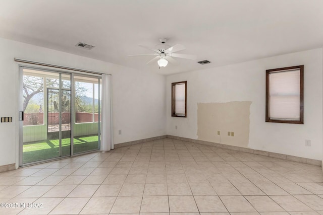 unfurnished room featuring baseboards, a ceiling fan, light tile patterned floors, and visible vents