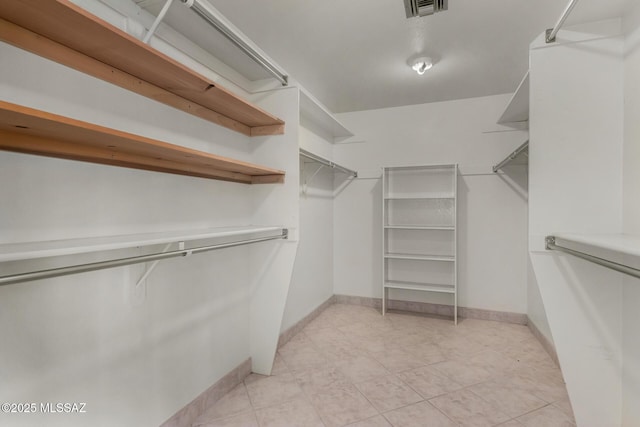 spacious closet featuring visible vents and light tile patterned floors