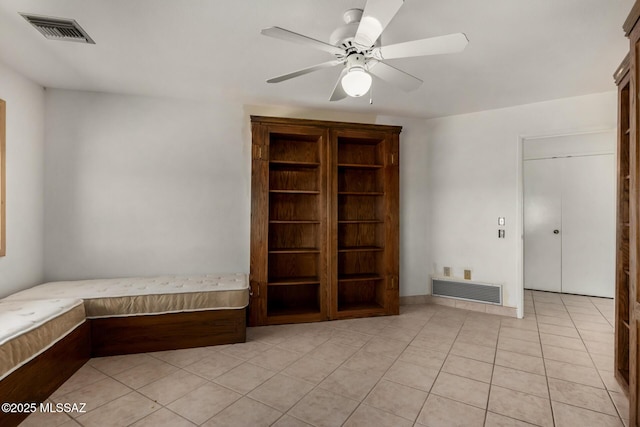 spare room with light tile patterned flooring, a ceiling fan, and visible vents