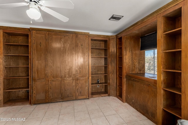 interior space featuring a ceiling fan, visible vents, and light tile patterned floors