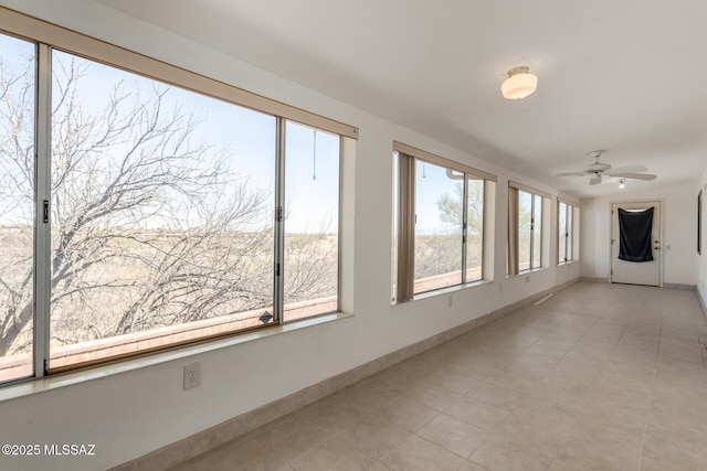 unfurnished sunroom with baseboards and tile patterned flooring
