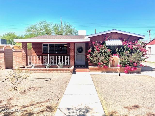 ranch-style house featuring brick siding and covered porch