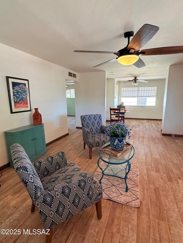 living room with visible vents, baseboards, and light wood-type flooring