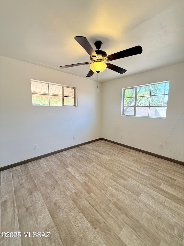 unfurnished room featuring baseboards, a ceiling fan, and light wood finished floors