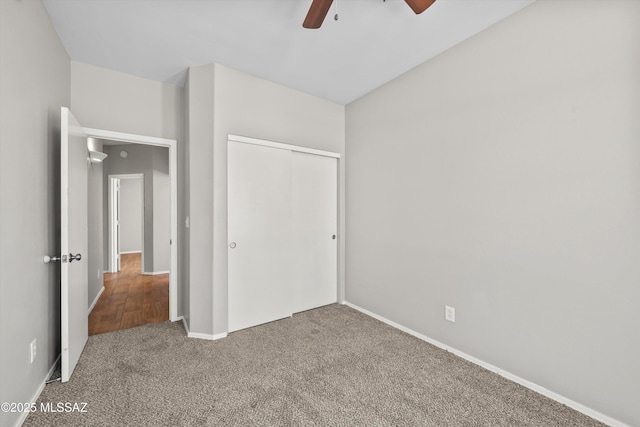unfurnished bedroom with carpet flooring, baseboards, ceiling fan, and a closet