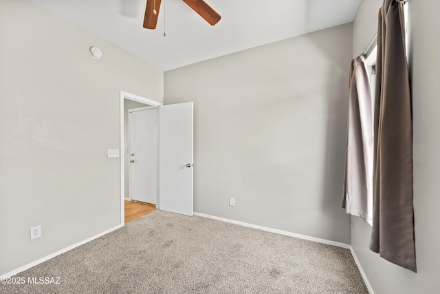unfurnished bedroom featuring baseboards, light carpet, and a ceiling fan
