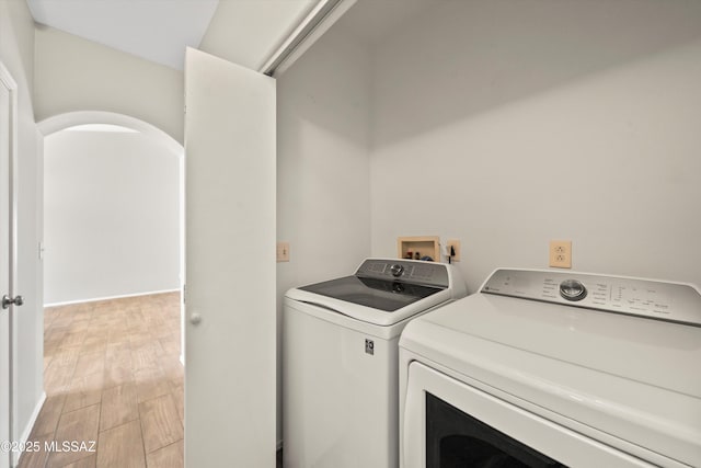 washroom with laundry area, light wood finished floors, and washing machine and dryer
