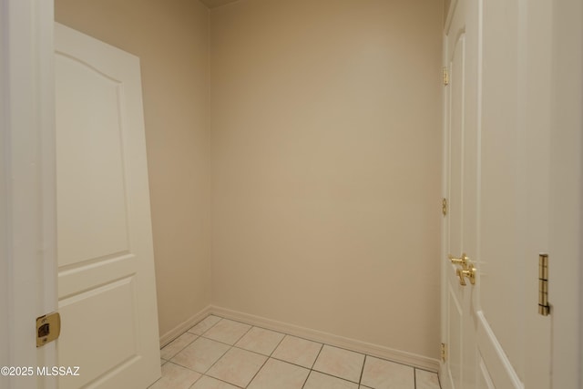 unfurnished room with light tile patterned flooring and baseboards