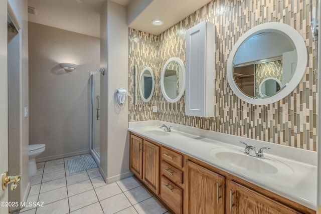 full bathroom featuring a shower stall, a sink, tile patterned floors, baseboards, and toilet