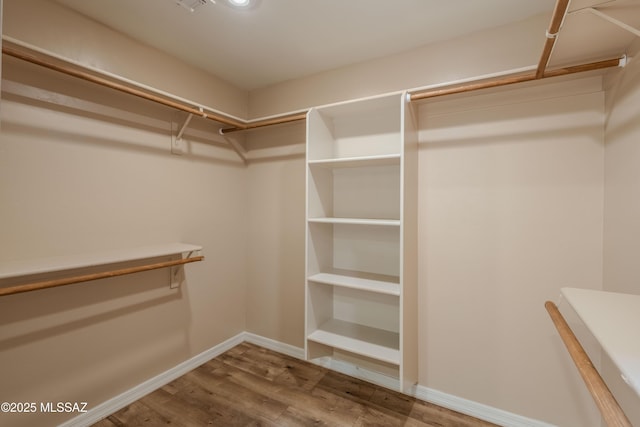walk in closet with wood finished floors