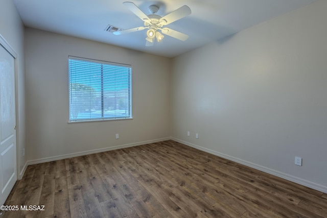 empty room with visible vents, baseboards, and wood finished floors