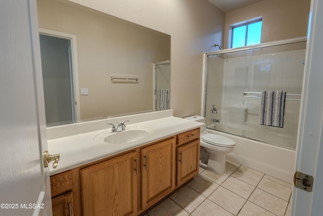 bathroom featuring combined bath / shower with glass door, tile patterned floors, vanity, and toilet