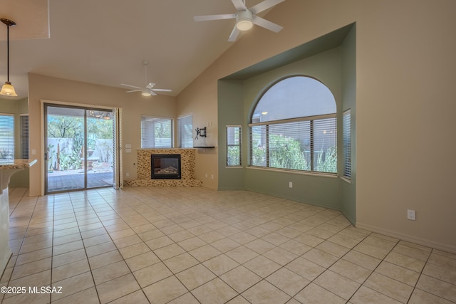 unfurnished living room with a ceiling fan, light tile patterned floors, high vaulted ceiling, and a tile fireplace