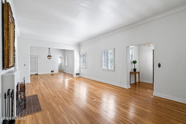 3263 E Broadway Blvd, Tucson, AZ 85716 - unfurnished living room featuring baseboards, ornamental molding, and light wood-type flooring