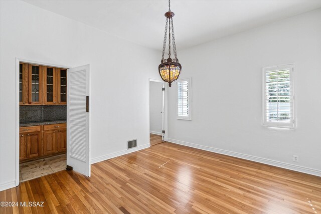 3263 E Broadway Blvd, Tucson, AZ 85716 - unfurnished dining area with light wood-style floors, a healthy amount of sunlight, an inviting chandelier, and visible vents
