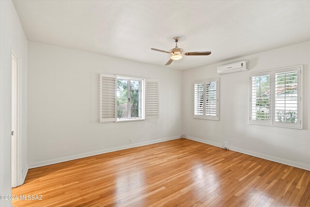 3263 E Broadway Blvd, Tucson, AZ 85716 - unfurnished room with baseboards, ceiling fan, light wood-style flooring, and a wall mounted air conditioner