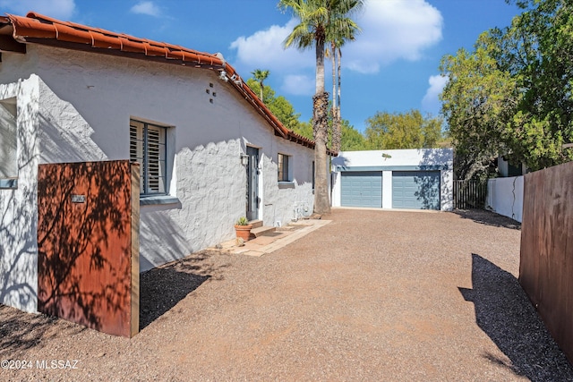 3263 E Broadway Blvd, Tucson, AZ 85716 - view of property exterior featuring an outdoor structure, fence, stucco siding, a tile roof, and a detached garage