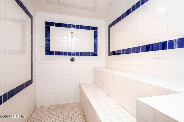 bathroom featuring tile walls and a tile shower
