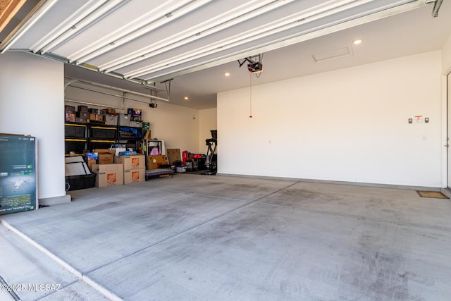garage with a garage door opener and recessed lighting
