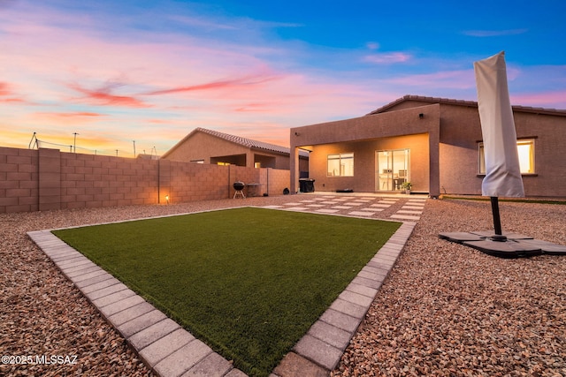 rear view of property with stucco siding, a patio area, and a chimney