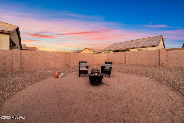 fenced backyard with a fire pit