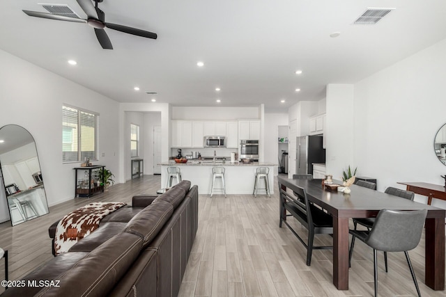 living room featuring light wood-style flooring, recessed lighting, and a ceiling fan