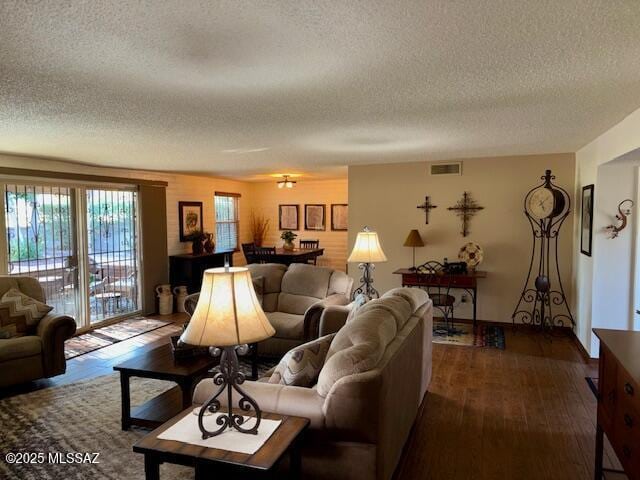215 E Los Rincones, Green Valley, AZ 85614 - living room featuring dark wood-style flooring, a textured ceiling, and visible vents