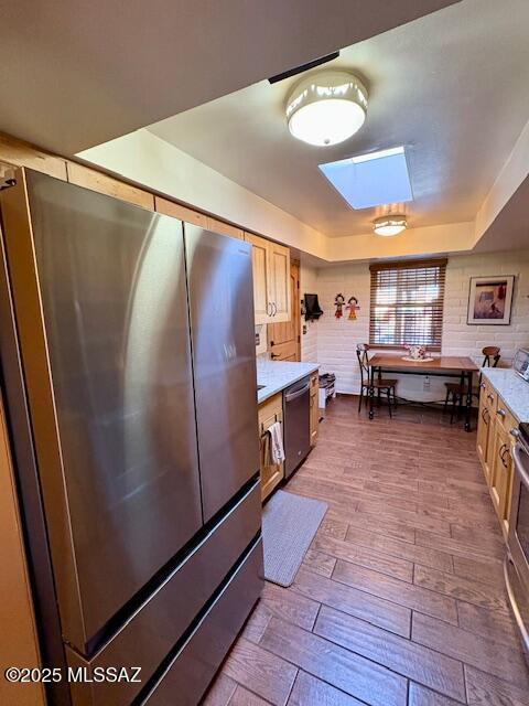 215 E Los Rincones, Green Valley, AZ 85614 - kitchen with appliances with stainless steel finishes, light countertops, a skylight, a tray ceiling, and dark wood-style floors