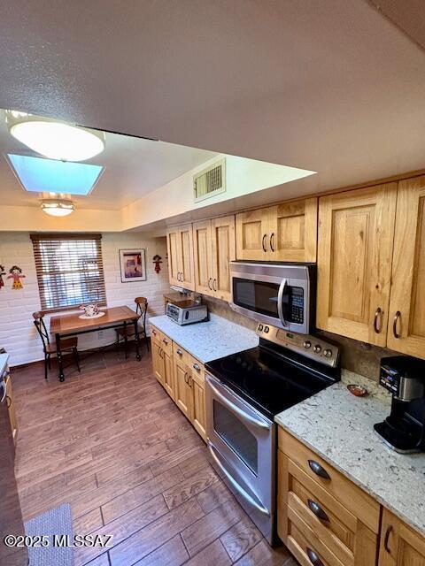 215 E Los Rincones, Green Valley, AZ 85614 - kitchen featuring visible vents, dark wood-style flooring, light stone counters, and stainless steel appliances