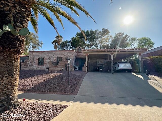 215 E Los Rincones, Green Valley, AZ 85614 - view of front of house featuring fence, driveway, and a carport