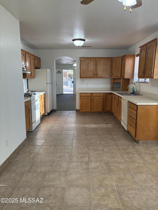 829 E Calle Esplendor, Nogales, AZ 85621 - kitchen featuring white appliances, ceiling fan, light countertops, under cabinet range hood, and arched walkways