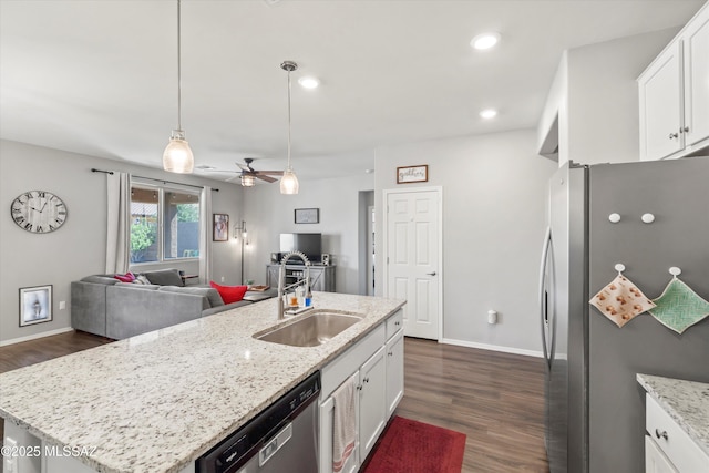 kitchen with a sink, white cabinets, open floor plan, stainless steel appliances, and dark wood-type flooring