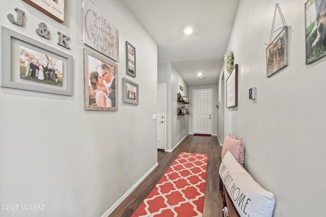 corridor with dark wood-type flooring, recessed lighting, and baseboards