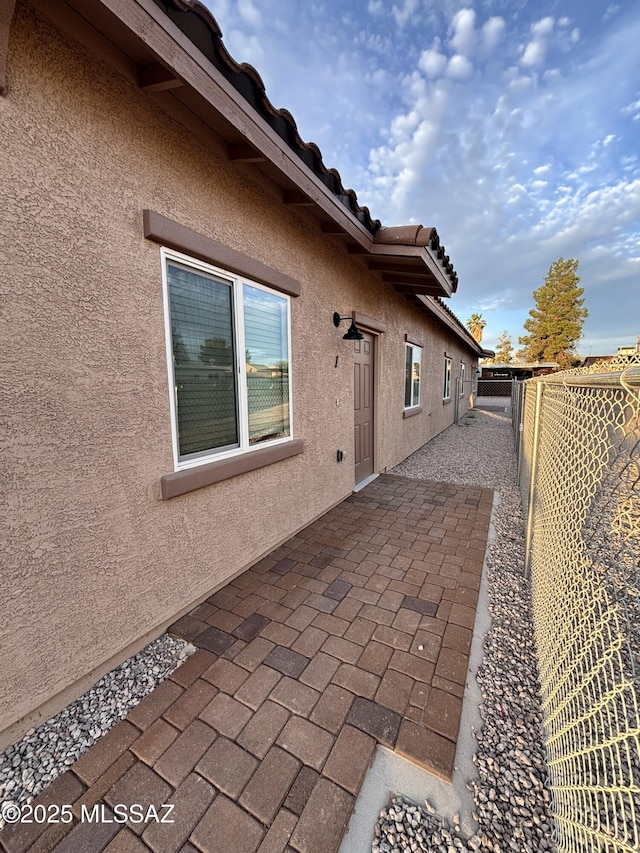 3649 S Belmar Ave, Tucson, AZ 85713 - view of side of property featuring stucco siding, a patio, a fenced backyard, and a tiled roof