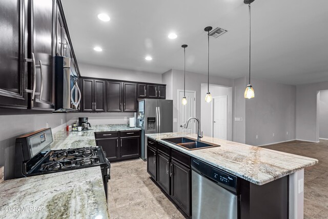 1020 E Wiley Squirrel Ln, Sahuarita, AZ 85629 - kitchen with visible vents, a kitchen island with sink, light stone countertops, a sink, and stainless steel appliances