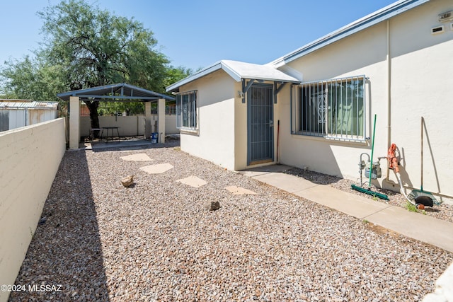 view of property exterior with fence, a patio, stucco siding, and a gazebo