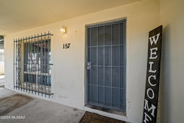 entrance to property featuring stucco siding