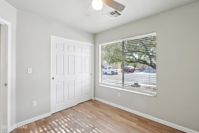 unfurnished bedroom featuring visible vents, baseboards, and wood finished floors